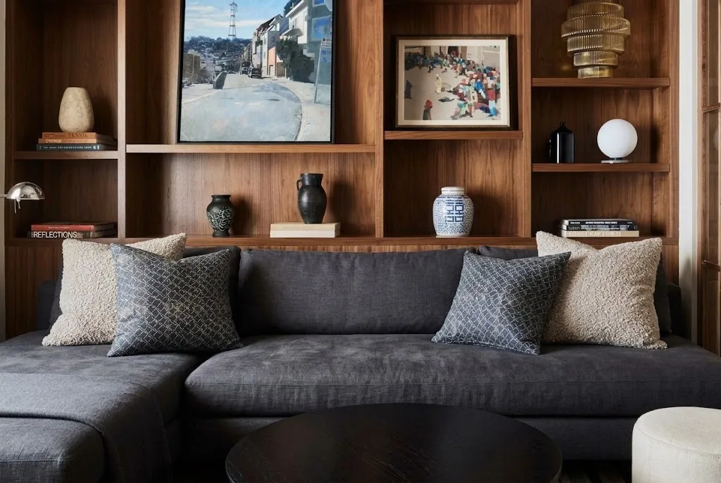 Apartment living room with framed personal photographs, favorite books, and meaningful decorative objects.